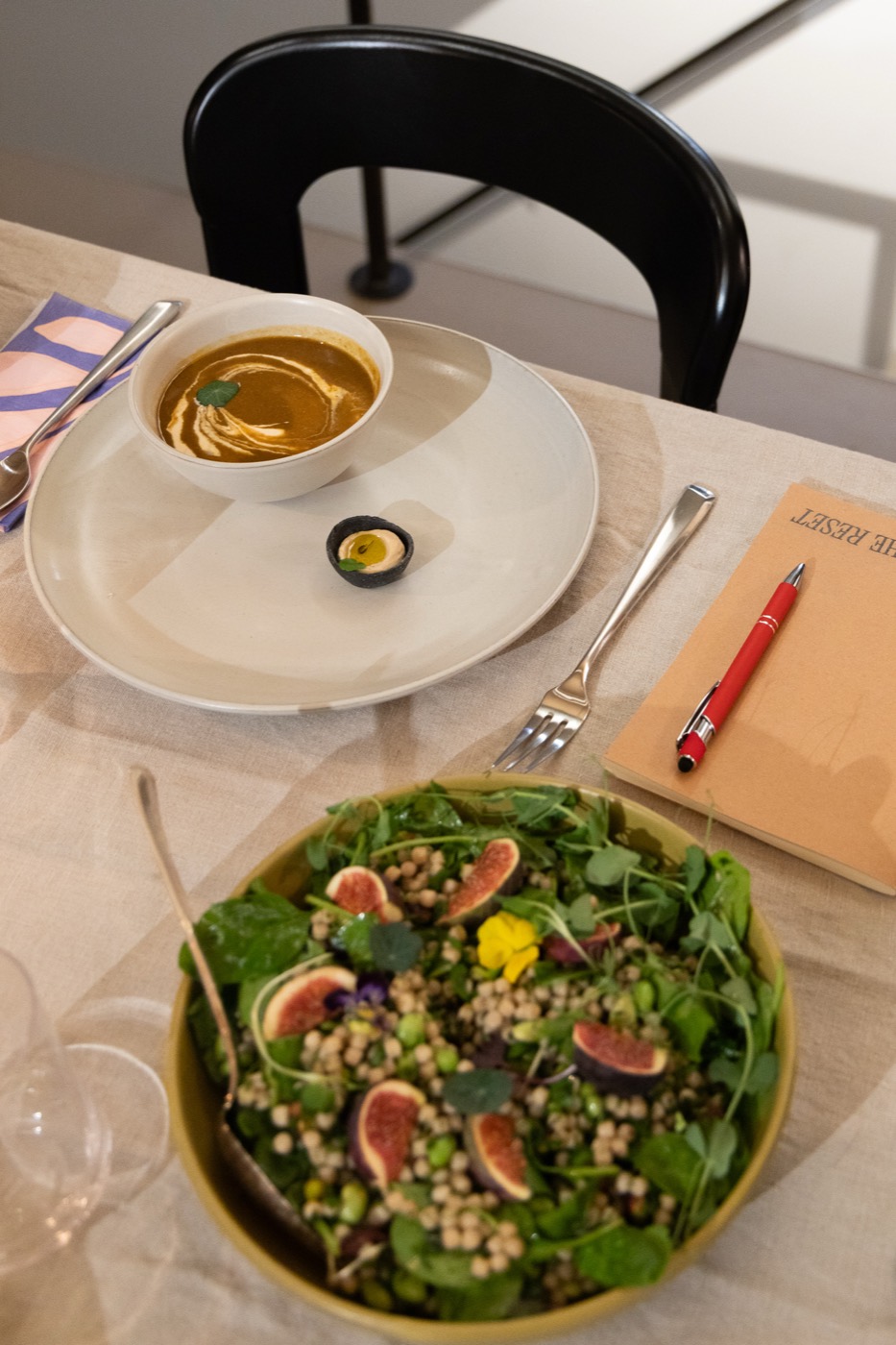 Salade met vijgen en een kom soep op de gedekte tafel